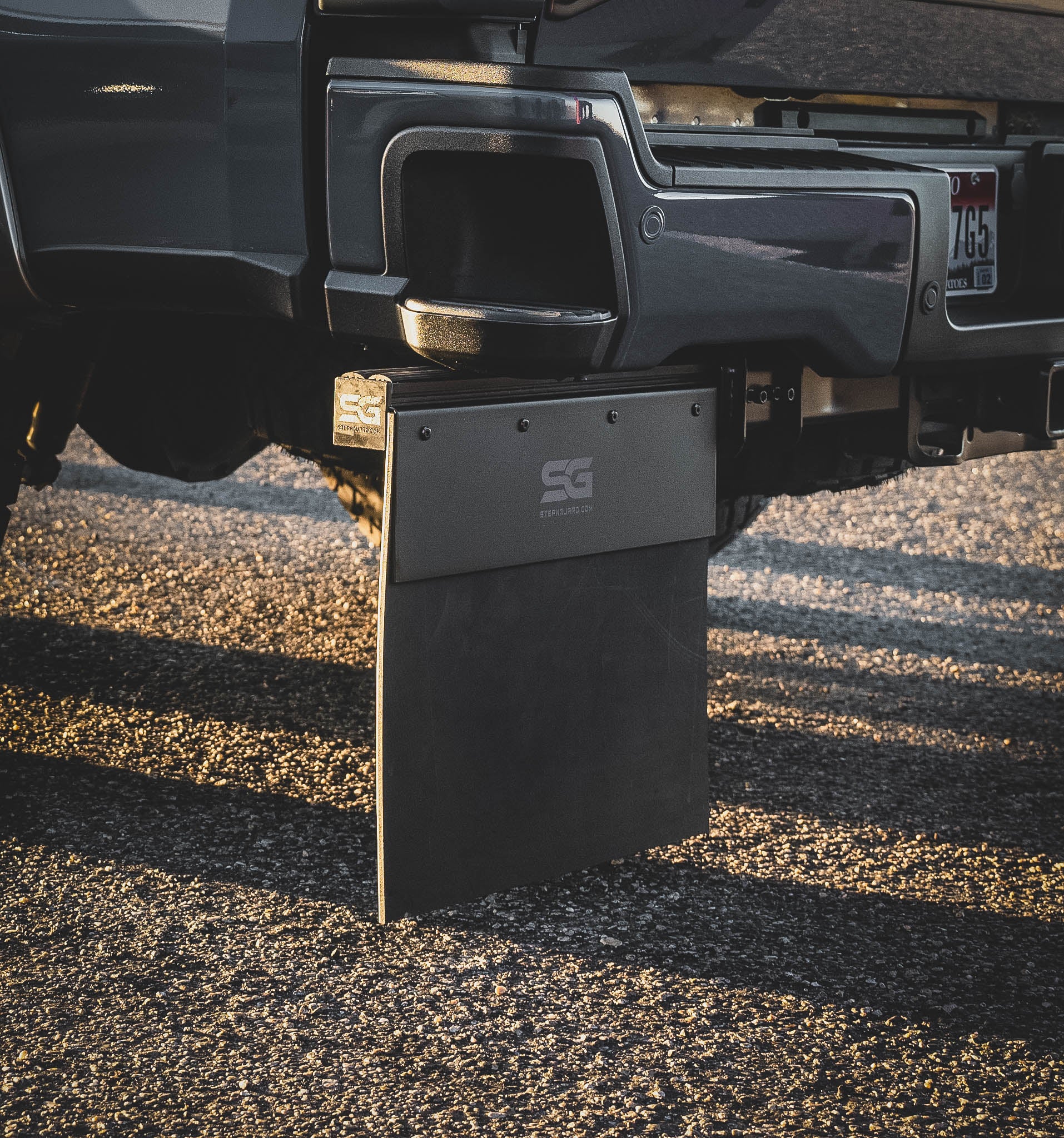 Up-close view of the Step N Guard modular mud flap assembly, showcasing the rust-resistant stainless steel anti-sail plate, bolt-on capability, and heavy-duty components.